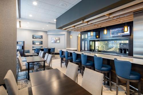 un restaurante con mesas y sillas y un bar en Courtyard by Marriott Boston Brookline, en Brookline