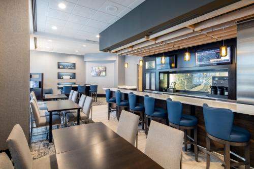 a restaurant with tables and chairs and a bar at Courtyard by Marriott Boston Brookline in Brookline