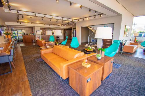 a large living room with a couch and chairs at H+ Hotel in Dourados