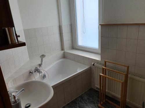 ein Bad mit einer Badewanne, einem Waschbecken und einem Fenster in der Unterkunft Kleiner Saal in Kurort Oberwiesenthal