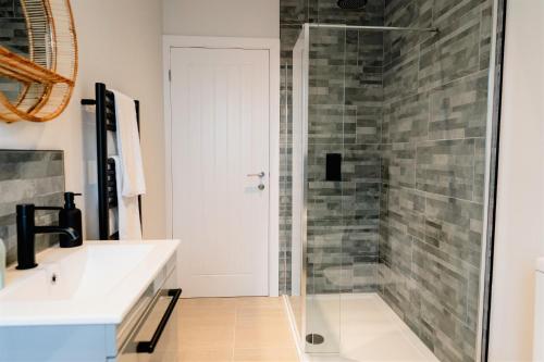 a bathroom with a glass shower and a sink at Sawley Cottage in Skipton