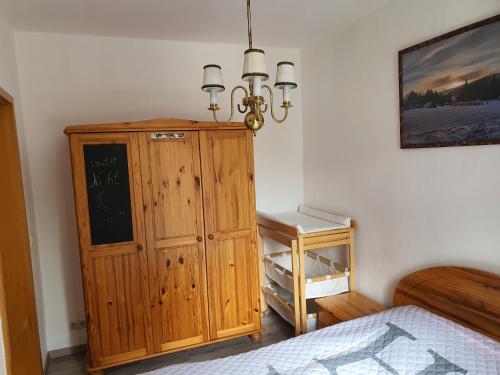 ein Schlafzimmer mit einem Holzschrank neben einem Bett in der Unterkunft Kleiner Saal in Kurort Oberwiesenthal