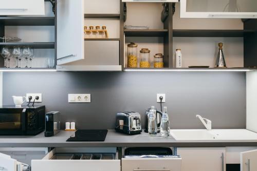 a kitchen with white cabinets and a counter top at NOZON Apartments & Wellness in Odorheiu Secuiesc