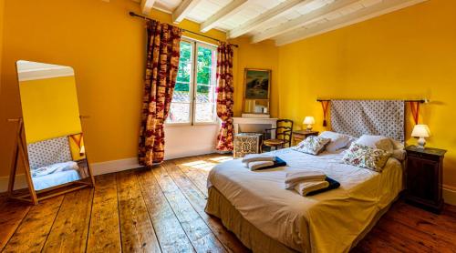 ein gelbes Schlafzimmer mit einem Bett und einem Fenster in der Unterkunft Villa de 9 chambres avec piscine privee terrasse amenagee et wifi a Castelmoron sur Lot in Castelmoron-sur-Lot