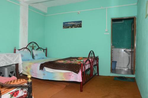 Habitación azul con 2 camas y espejo. en Everett Hut, en Darjeeling