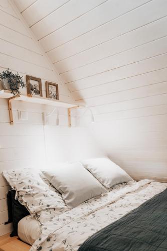 Bett in einem Zimmer mit weißer Decke in der Unterkunft Czuła Chata Ojców in Prądnik Czajowski