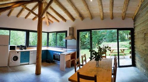 d'une cuisine et d'une salle à manger avec une table et quelques fenêtres. dans l'établissement Gite du Moulin, à Sainte-Marguerite-Lafigère