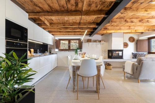 a kitchen and dining room with a table and chairs at El Roure in Molló