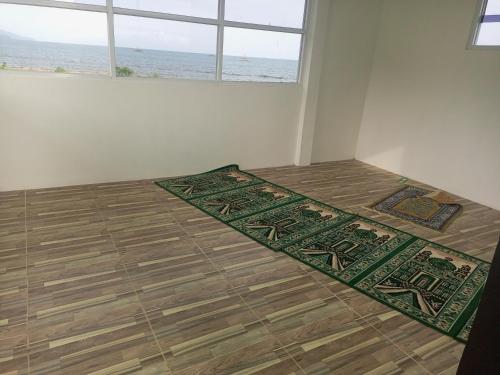 Pokój z dwoma dywanami na podłodze przed oknem w obiekcie Penginapan Lamban Queens Kamar Double Bed Lantai Bawah w mieście Kalianda