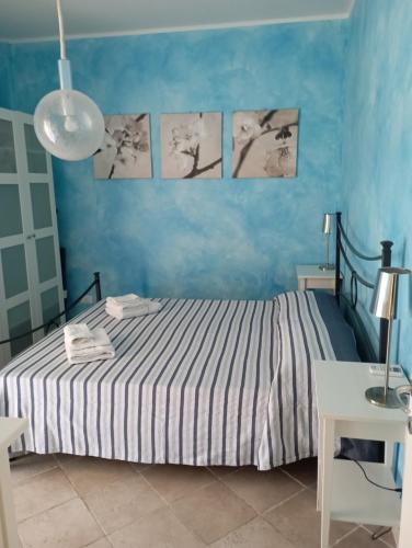 ein Schlafzimmer mit einem Bett mit blauen Wänden in der Unterkunft Casa Emily in Marinella di Sarzana