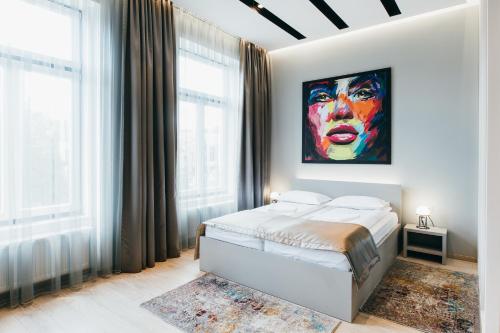 a bedroom with a bed and a painting on the wall at NOZON Apartments & Wellness in Odorheiu Secuiesc