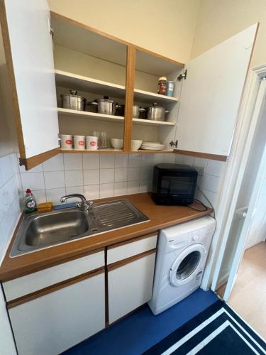 a kitchen with a sink and a washing machine at Apartament Kings Cross in London