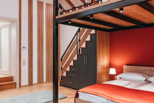 a bedroom with a loft bed and a staircase at NOZON Apartments & Wellness in Odorheiu Secuiesc