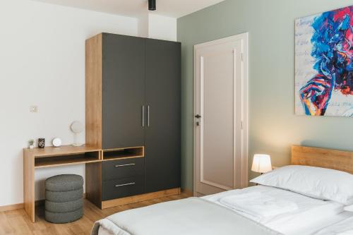 a bedroom with a bed and a cabinet and a desk at NOZON Apartments & Wellness in Odorheiu Secuiesc