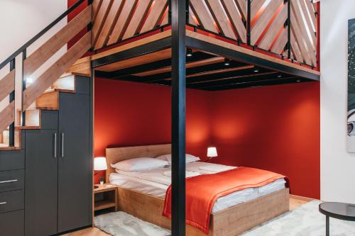 a loft bed in a bedroom with red walls at NOZON Apartments & Wellness in Odorheiu Secuiesc