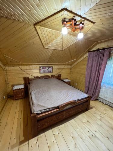 ein Schlafzimmer mit einem Bett in einem Holzzimmer in der Unterkunft Садиба ''Файна Гоффа'' in Werchowyna