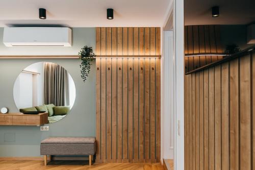 a wooden partition in a room with a mirror at NOZON Apartments & Wellness in Odorheiu Secuiesc