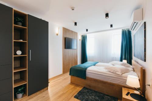 a bedroom with a bed and a book shelf at NOZON Apartments & Wellness in Odorheiu Secuiesc