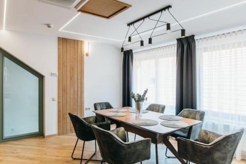 a dining room with a table and chairs at NOZON Apartments & Wellness in Odorheiu Secuiesc