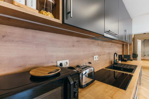 a kitchen with a stove top oven next to a sink at NOZON Apartments & Wellness in Odorheiu Secuiesc