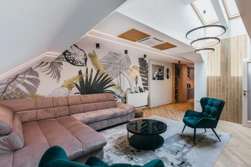 a living room with a couch and a chair at NOZON Apartments & Wellness in Odorheiu Secuiesc