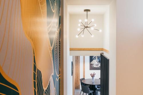 a hallway with a table and a chandelier at NOZON Apartments & Wellness in Odorheiu Secuiesc