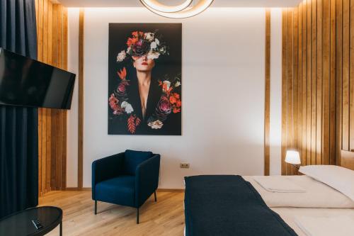 a bedroom with a bed and a painting of a woman at NOZON Apartments & Wellness in Odorheiu Secuiesc