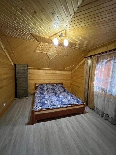 a bedroom with a bed in a wooden room at Садиба Файна Гофа in Verkhovyna