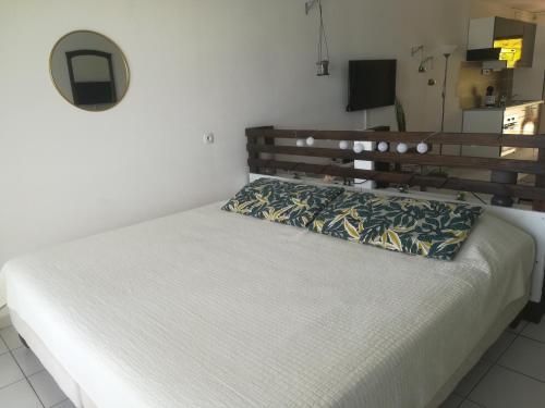 Bett in einem Schlafzimmer mit einem Kopfteil aus Holz in der Unterkunft Happy Residence - Orient Beach 09 in Saint Martin