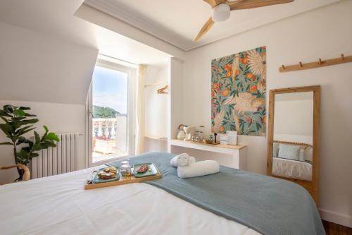 a bedroom with a bed with a tray of food on it at Far Out Inn - Yoga guesthouse in San Sebastián
