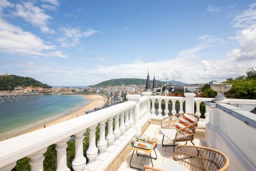 a balcony with chairs and a view of the beach at Far Out Inn in Donostia-San Sebastián