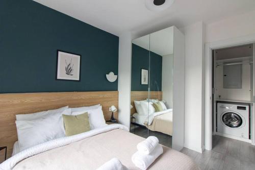 1 dormitorio con 1 cama grande y espejo en Newly Built Bright 2BR w Free Shuttle #68, en Estambul