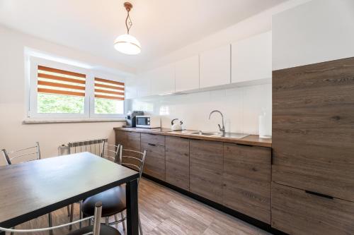 a kitchen with white cabinets and a table and a table and chairs at Apartament rodzinny in Solina