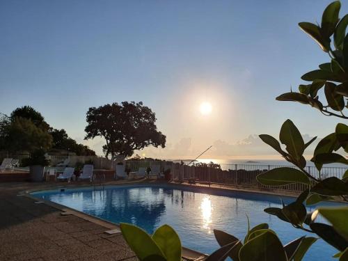 - une piscine avec vue sur le coucher du soleil en arrière-plan dans l'établissement villa CASA TOTTI vue mer avec piscine, à Porto-Vecchio