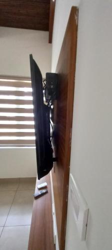 a television on a wooden shelf in a room at Eka Homes 3BHDK Villa in Trivandrum