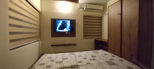 a bedroom with a bed and a tv on the wall at Eka Homes 3BHDK Villa in Trivandrum