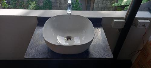 a bathroom with a white sink on a counter at Eka Homes 3BHDK Villa in Trivandrum