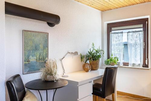 ein Büro mit einem Schreibtisch, 2 Stühlen und einem Tisch in der Unterkunft Ferienwohnung Kalkau in Lichtenstein