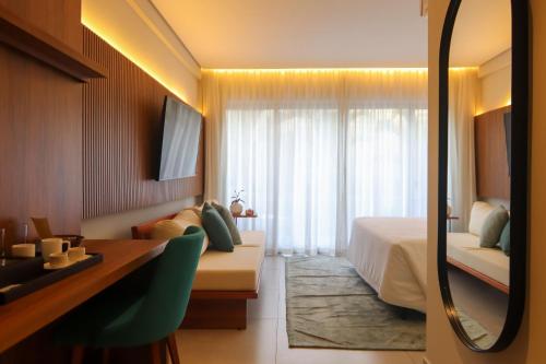 a hotel room with a bed and a desk and a window at île de Pipa - Ma Plage Hotel in Pipa