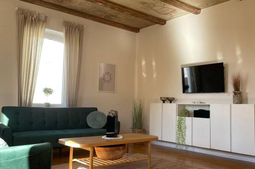 een woonkamer met een groene bank en een tv bij Gröön Ruum in Leer