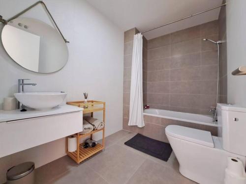 uma casa de banho com um lavatório, um WC e uma banheira em Charming flat close to the beach em Canet de Berenguer