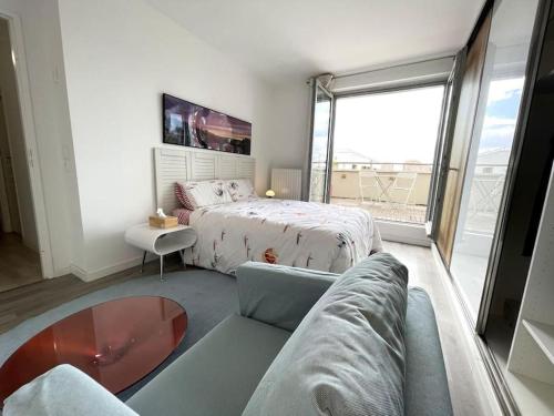 - une chambre avec un lit, un canapé et une fenêtre dans l'établissement Magnifique chambre Avec terrasse (option clim ), à Bagneux
