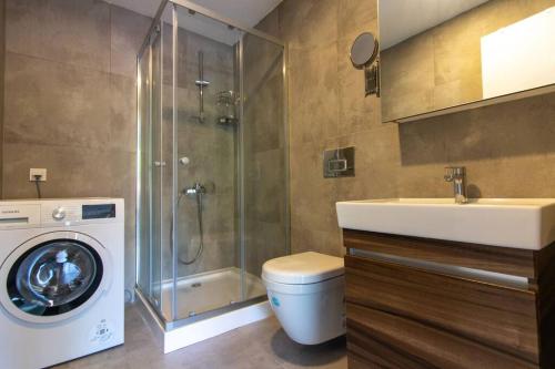 een badkamer met een wasmachine en een wastafel bij Warm Bright 2BR Urban Home w/ Free Shuttle+Parking #127 in Istanbul