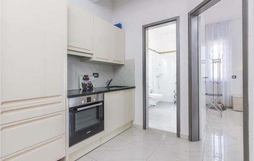 een keuken met witte kasten en een fornuis met oven bij Stunning Apartment In Funtana With Wifi in Funtana