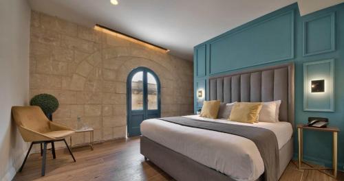 a bedroom with a large bed and a chair at 23 Boutique Hotel in Il-Furjana