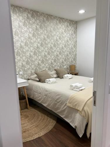 a bedroom with a bed and a wall at Porto Apartamento relaxante na cidade in Porto