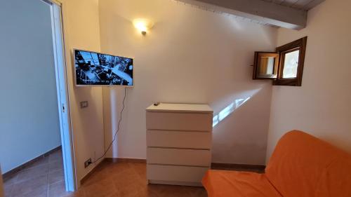 a room with a staircase with a tv on the wall at VILLA BIFAMILIARE SCOPELLO in Scopello