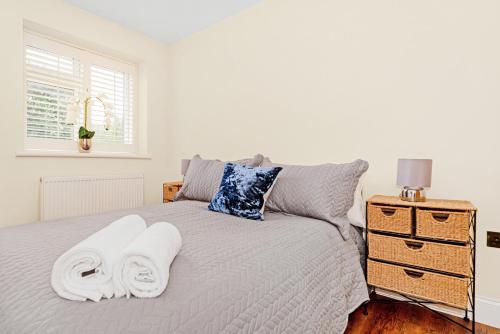 Kempton Park Views -Two Double Bedroom Luxury Apartments في Sunbury Common: غرفة نوم عليها سرير وفوط