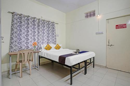 a room with a bed and a table and a chair at SPOT ON Hotel Sk Star in Nagpur