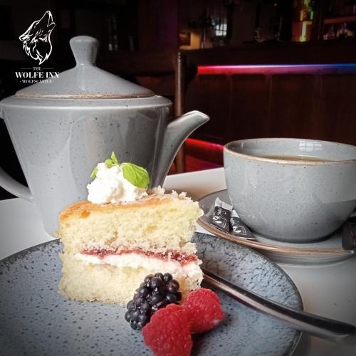 a piece of cake on a plate next to a cup of coffee at The Wolfe Inn Wolfscastle in Haverfordwest